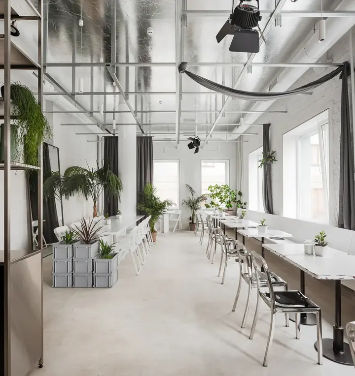 Comedor de un espacio diseñado por ALUZINA en Medellín de día, con luz natural, ventanales blancos, sillas de cromo y plantas